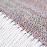 Nahaufnahme Textil und Fransensaum des Alpaka Plaids in creme zeigen die feine Verarbeitung