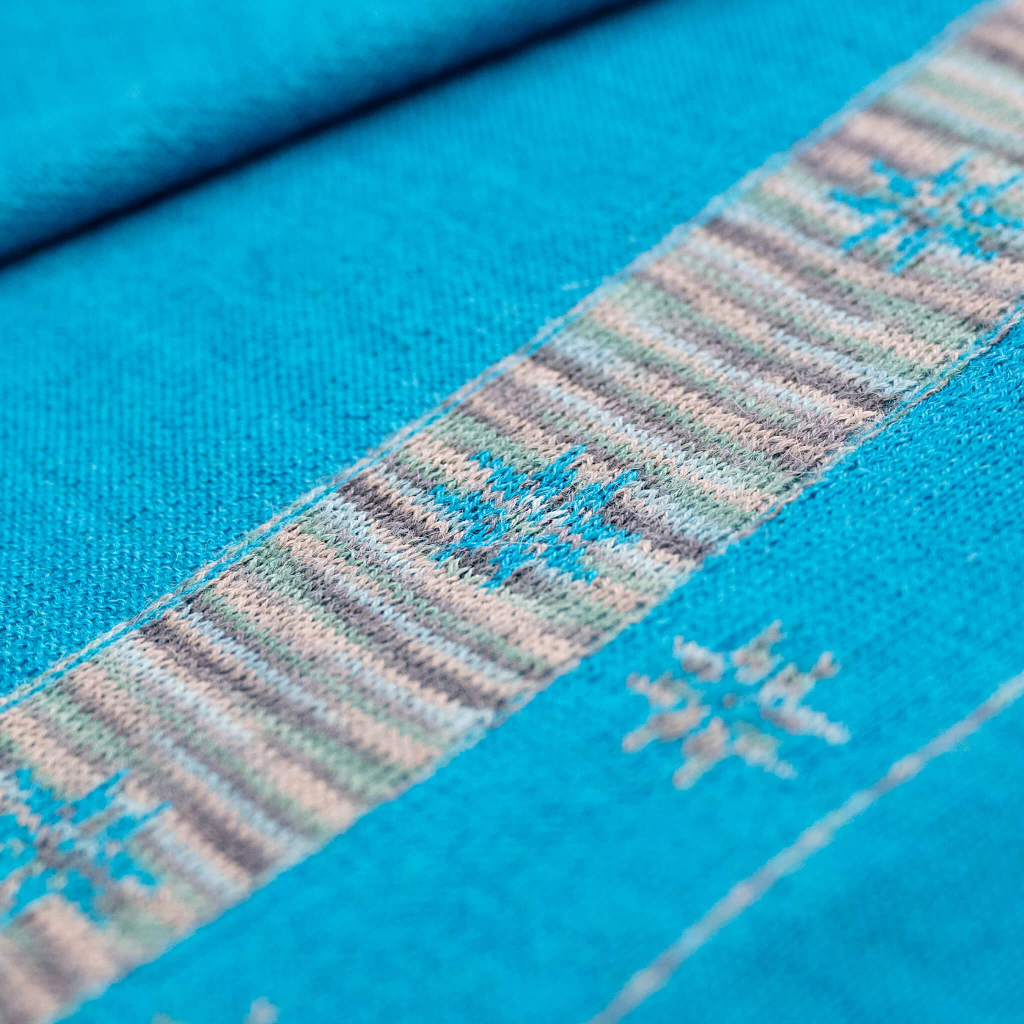 Nahaufnahme Textil des Edelweiß Alpaka Schals in türkis