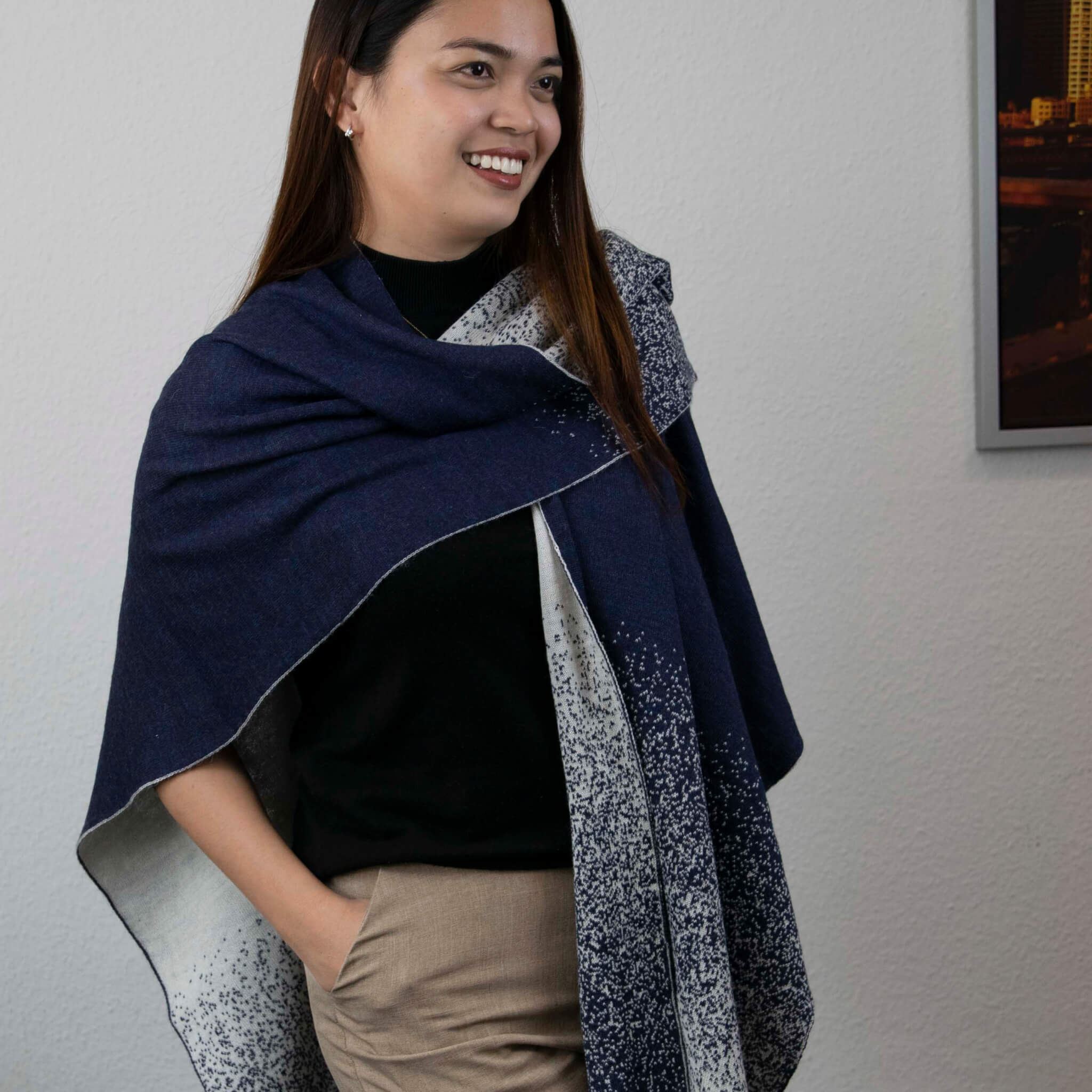 Lächelndes Model trägt den bequemen Yana Alpaka Poncho Schal von Alpakin in Farbe dunkelblau