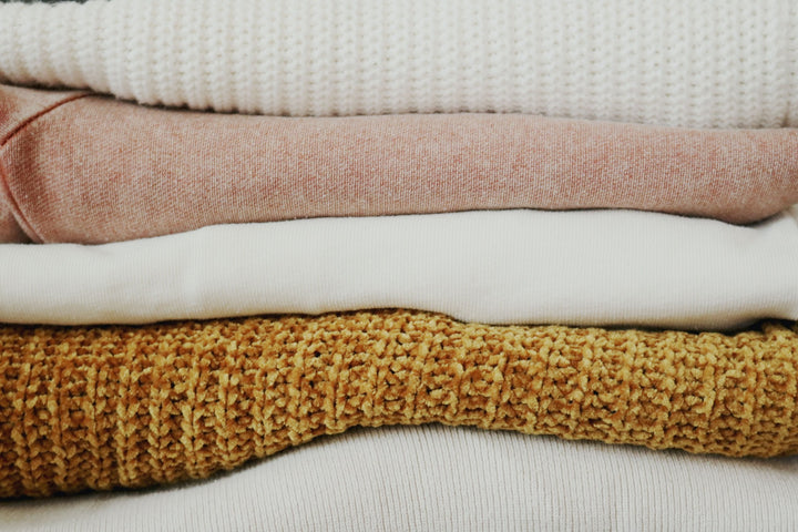 Flauschige Woll-Pullover aufeinander gelegt in verschiedenen Farben