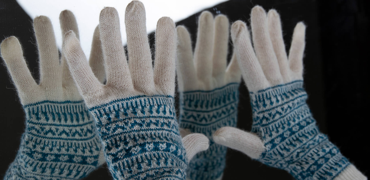 Alpaka Handschuhe in türkis und weiß im Spiegelbild eines Spiegels