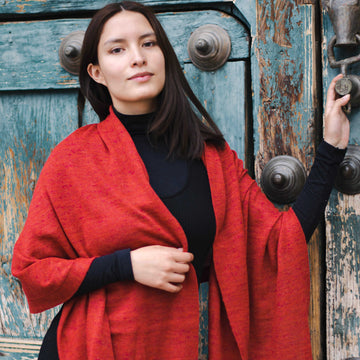 Alpaka Schal einfarbig rot getragen von peruanischem Model vor bunter Tür