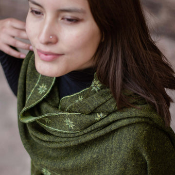 Alpaka Schal für Damen mit Muster in dunkelgrün getragen von peruanischem Model im Freien