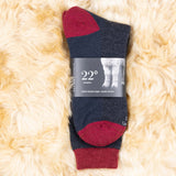 Dunkelgraue Alpaka Thermosocken in Verpackung auf kuscheligem Alpaka Fell platziert
