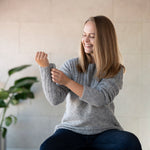 Frau mit grauem Andes Alpaka Pullover aus 100% Babyalpaka richtet ihren Ärmel