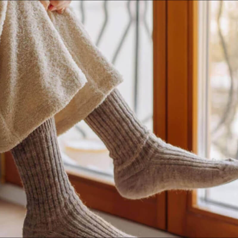 Frau mit wärmsten Socken aus Alpakawolle als Kuschelsocken