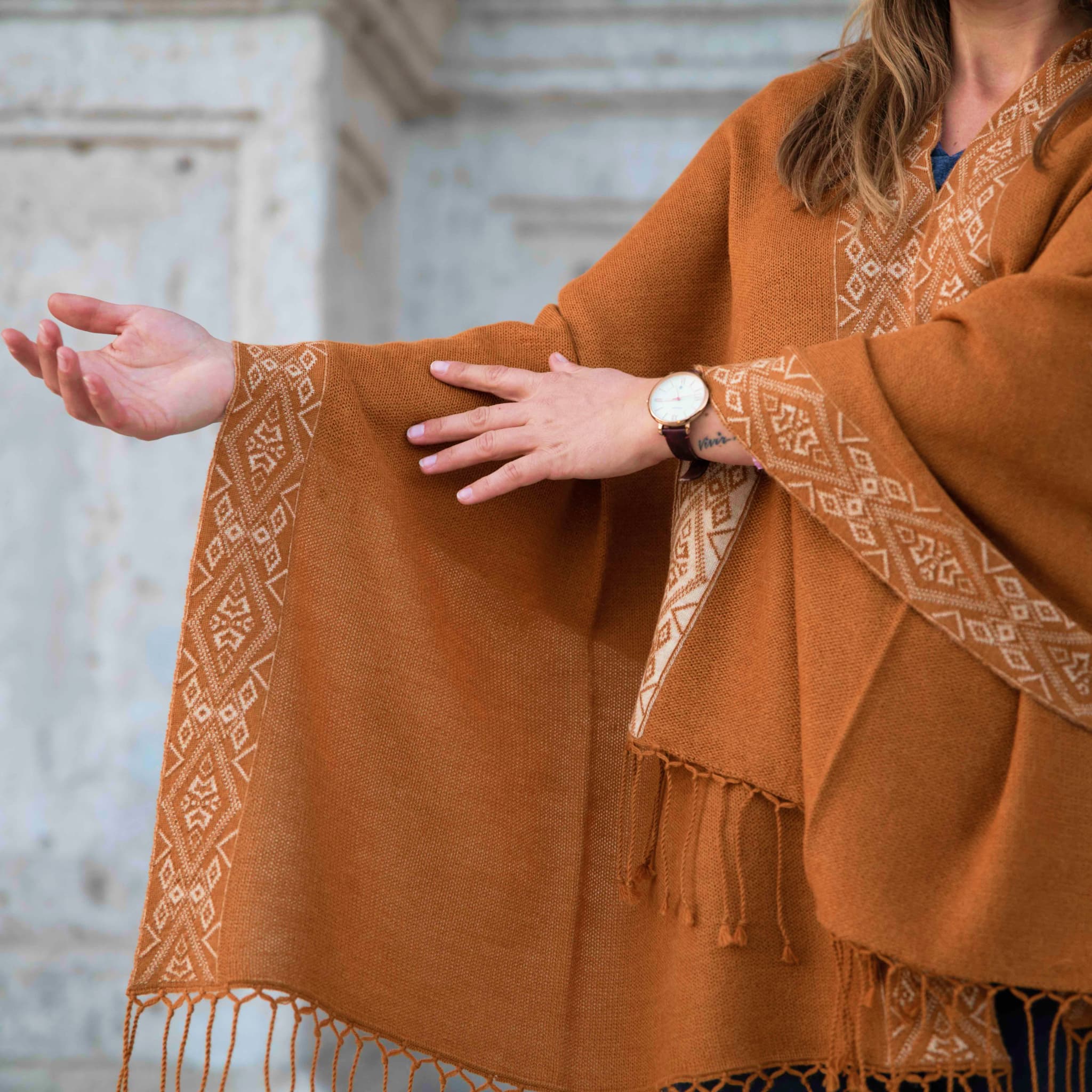 Detailansicht der Musterung des Flor Alpaka Poncho Schals von Alpakin in Kamel mit Model