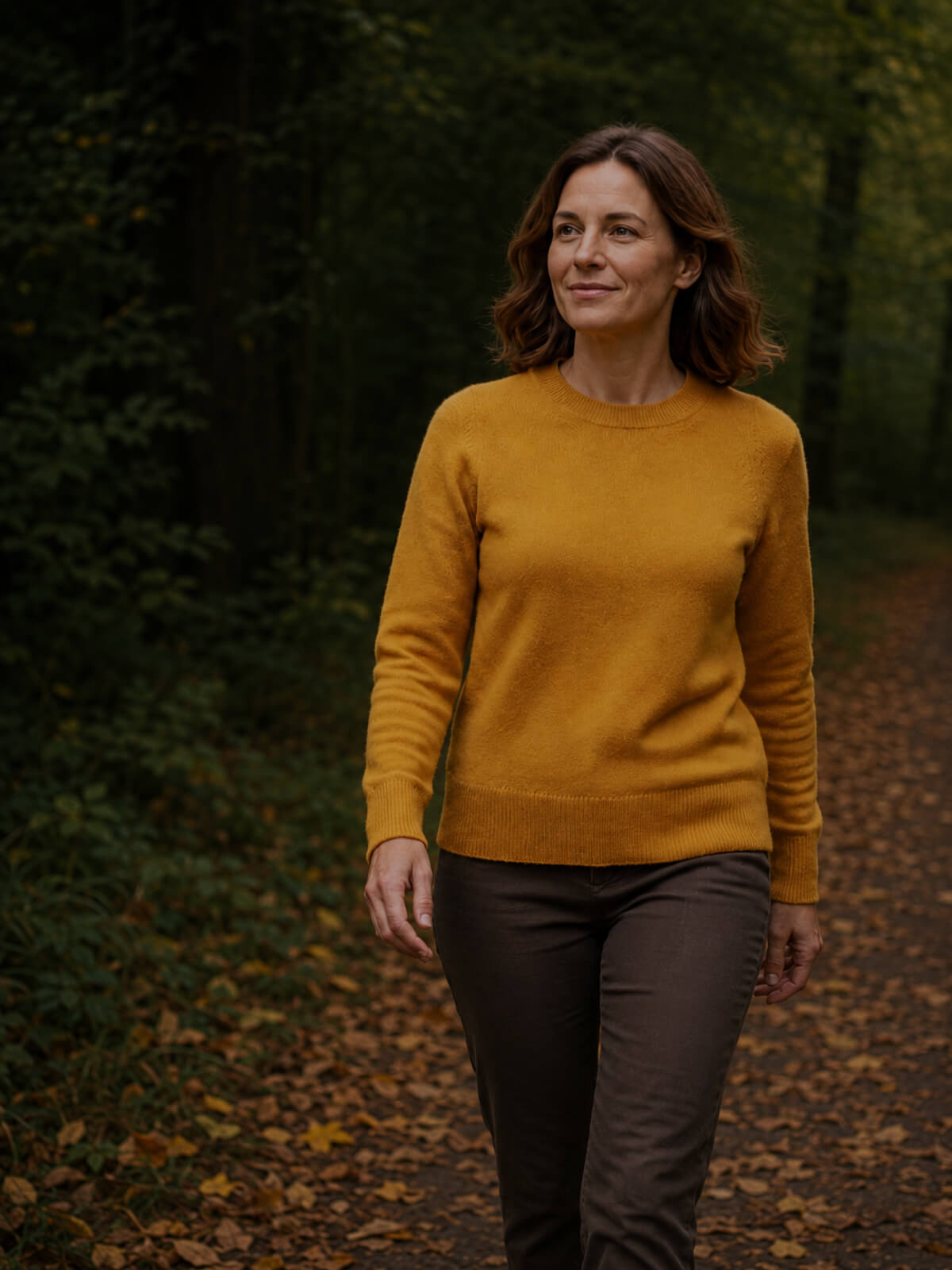 Frau beim Herbstspaziergang mit senfgelbem Alpaka Pullover