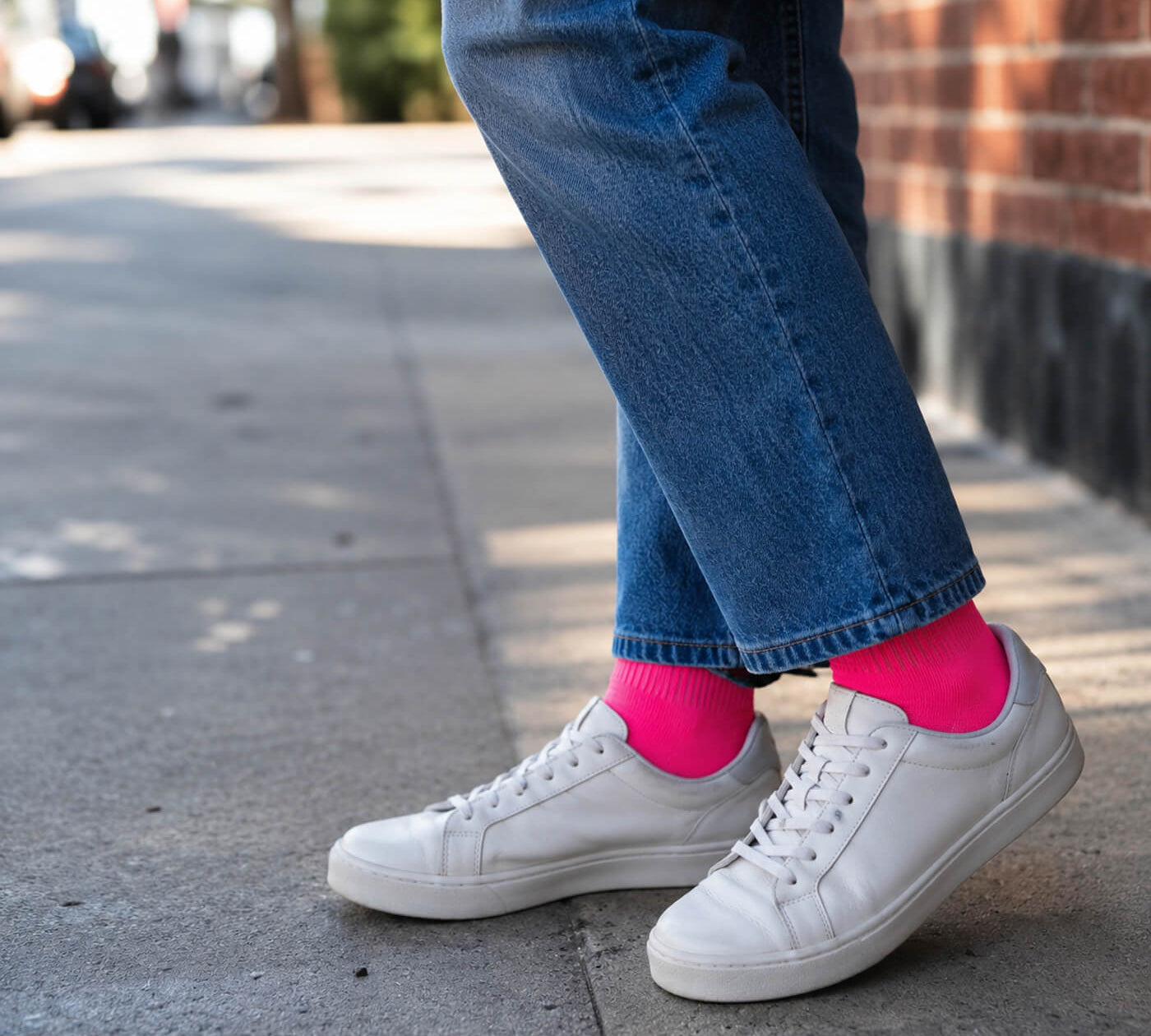 Pinke Kompressionsstrümpfe im Freizeitlook mit Jeans und weißen Sneaker Schuhen