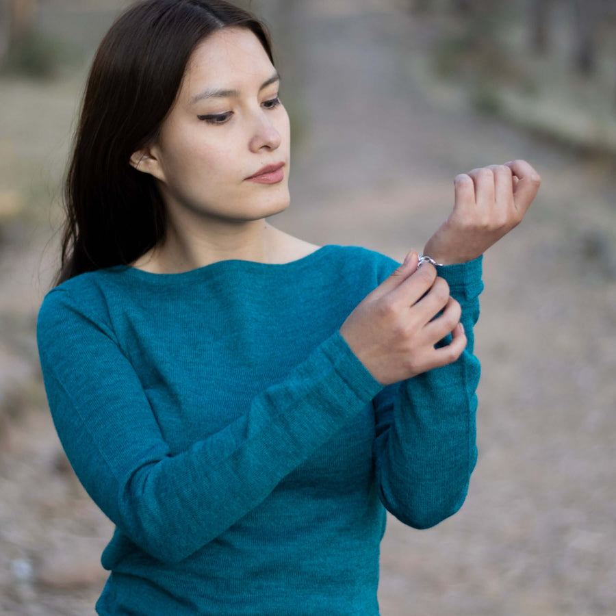 Alpaka Pullover für Damen Luna von Alpakin in türkis von peruanischem Model im Freien getragen