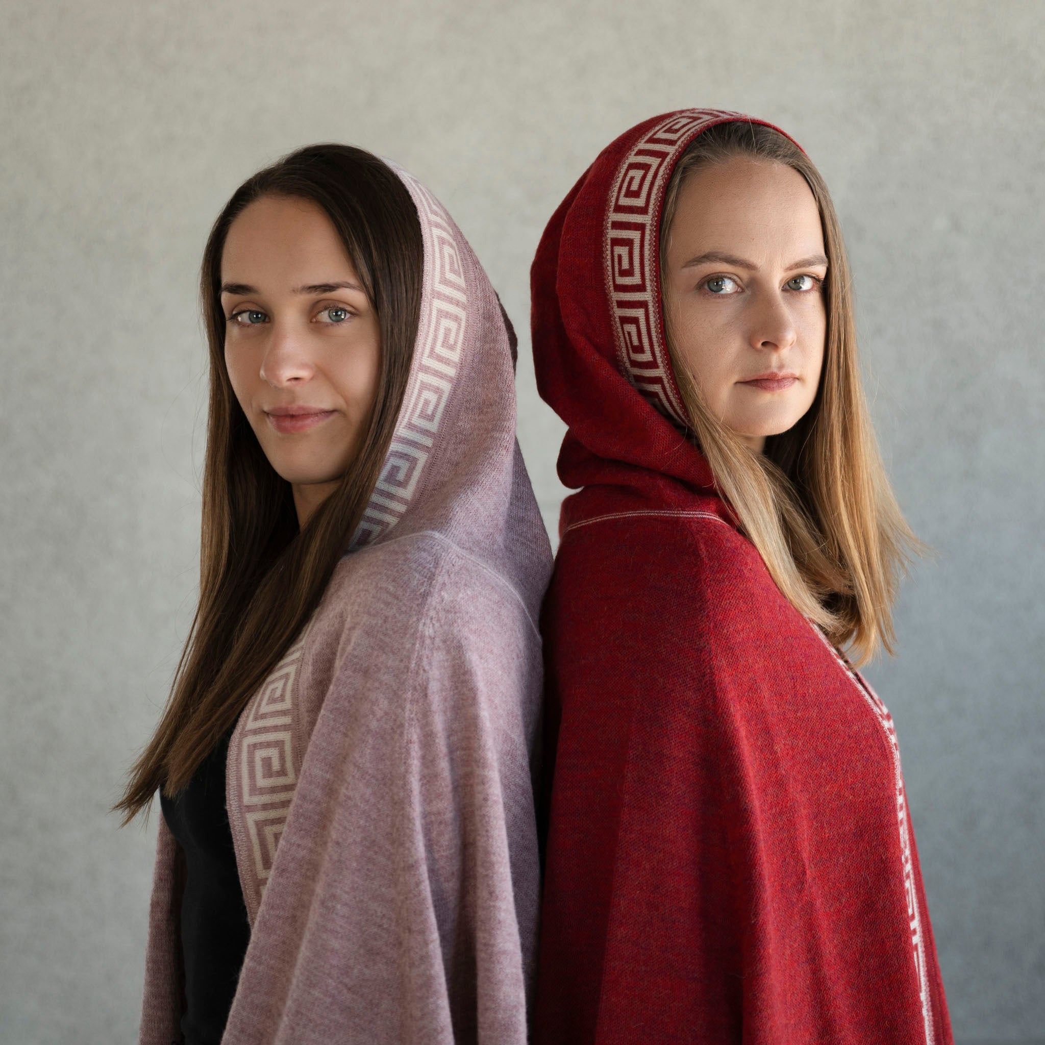 Zwei Frauen tragen Luz Poncho in rosa und rot von Alpakin aus feinster Babyalpaka Wolle, ohne Zugabe von Synthetik