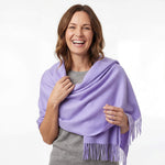 Frau mit braunen, kurzen Haaren trägt den Royal Alpaka Schal in Frühlingsfarbe lila und ist begeistert von der Weichheit und dem natürlichen Glanz des Schals