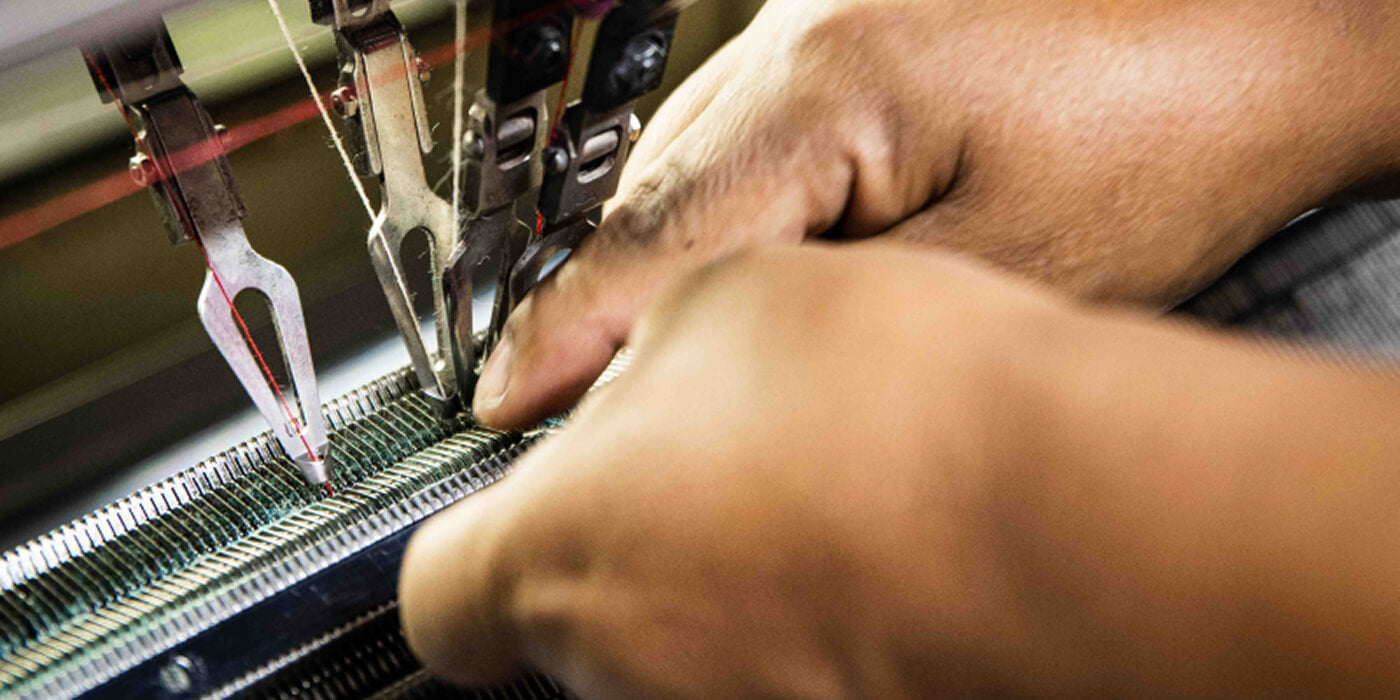 Hände an der Maschine in der Alpakin Manufaktur für Premium Alpaka Kleidung in Peru