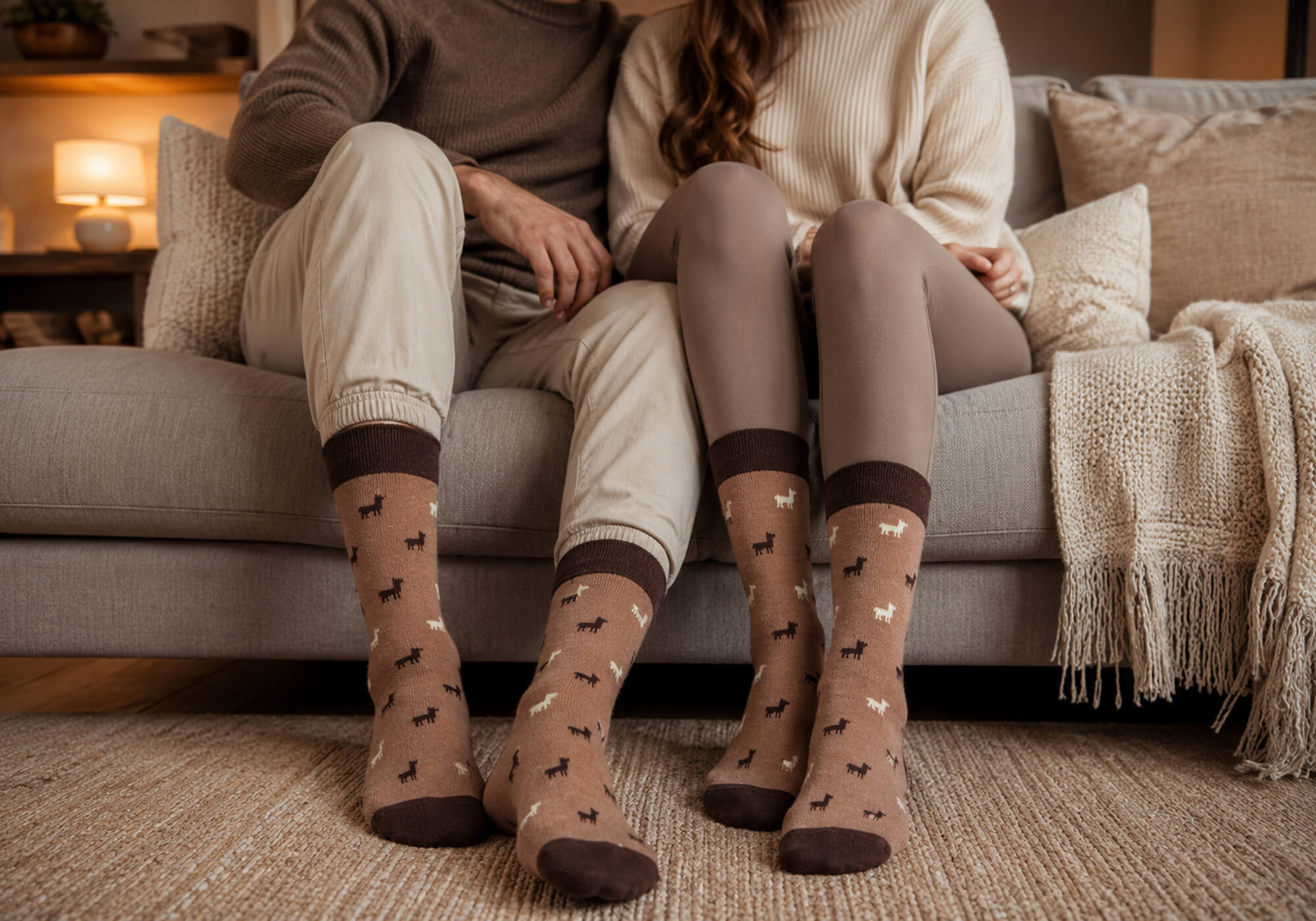 Wohlfühlmoment eines Paares auf dem Sofa mit ihren Naturfarben Socken mit Alpaka Motiv