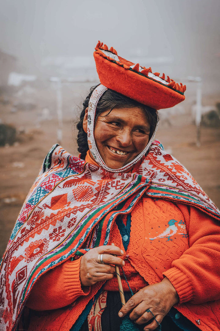 Peruanerin trägt typisch peruanischen, bunten Poncho im Freien unter einer Strickjacke und mit Hut