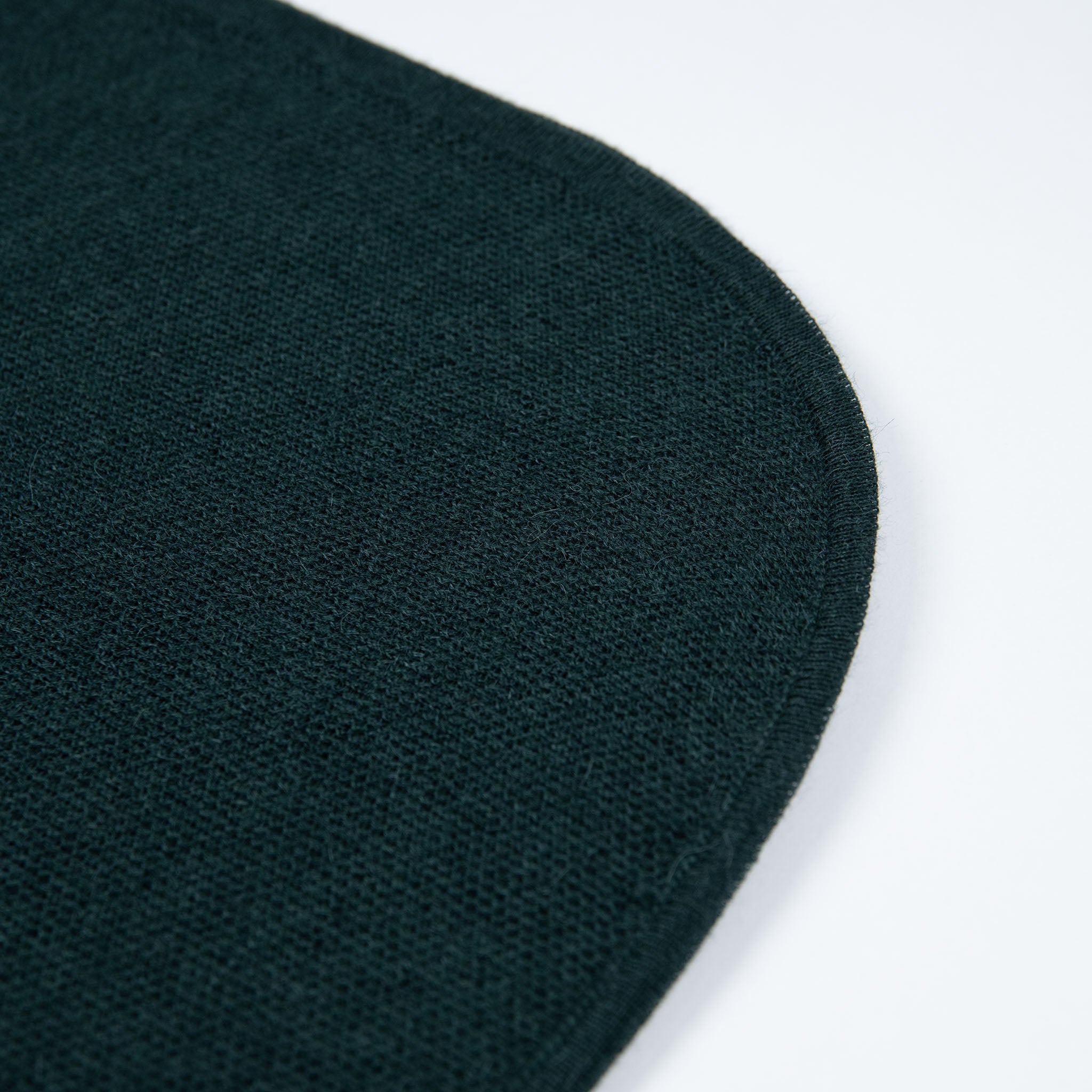 Abgerundeter Rand des Alpaka Ponchos für Herren in dunkelgrün