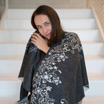 Frau hüllt sich in ihren kuschelweichen Babyalpaka Wendeponcho von Alpakin, der weich wie Kaschmir ist