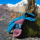 Wärmste Alpaka Socken in Beere und dunkeltürkis vor Bergkulisse in Peru