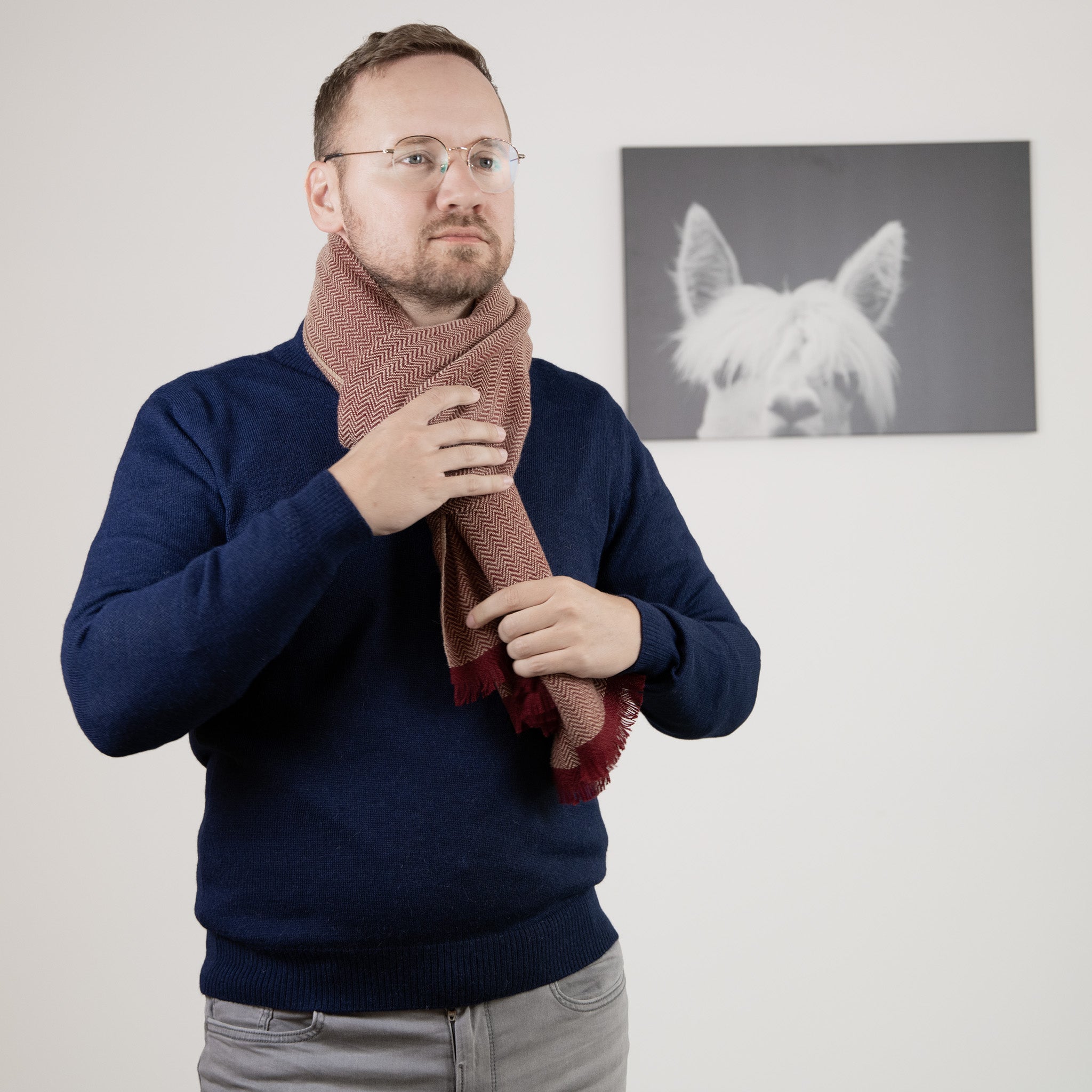 Männliches Model trägt den Alpaka Schal mit Fischgrätenmuster in dunkelrot in Knoten-Optik