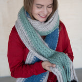 Blondes Model fühlt die sanfte Textur ihres großen Alpaka Schals aus 100% Babyalpaka