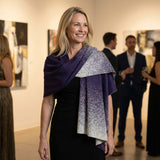Blonde Frau trägt auf einer Abendveranstaltung den eleganten Poncho Yana aus Alpakawolle in dunkellila